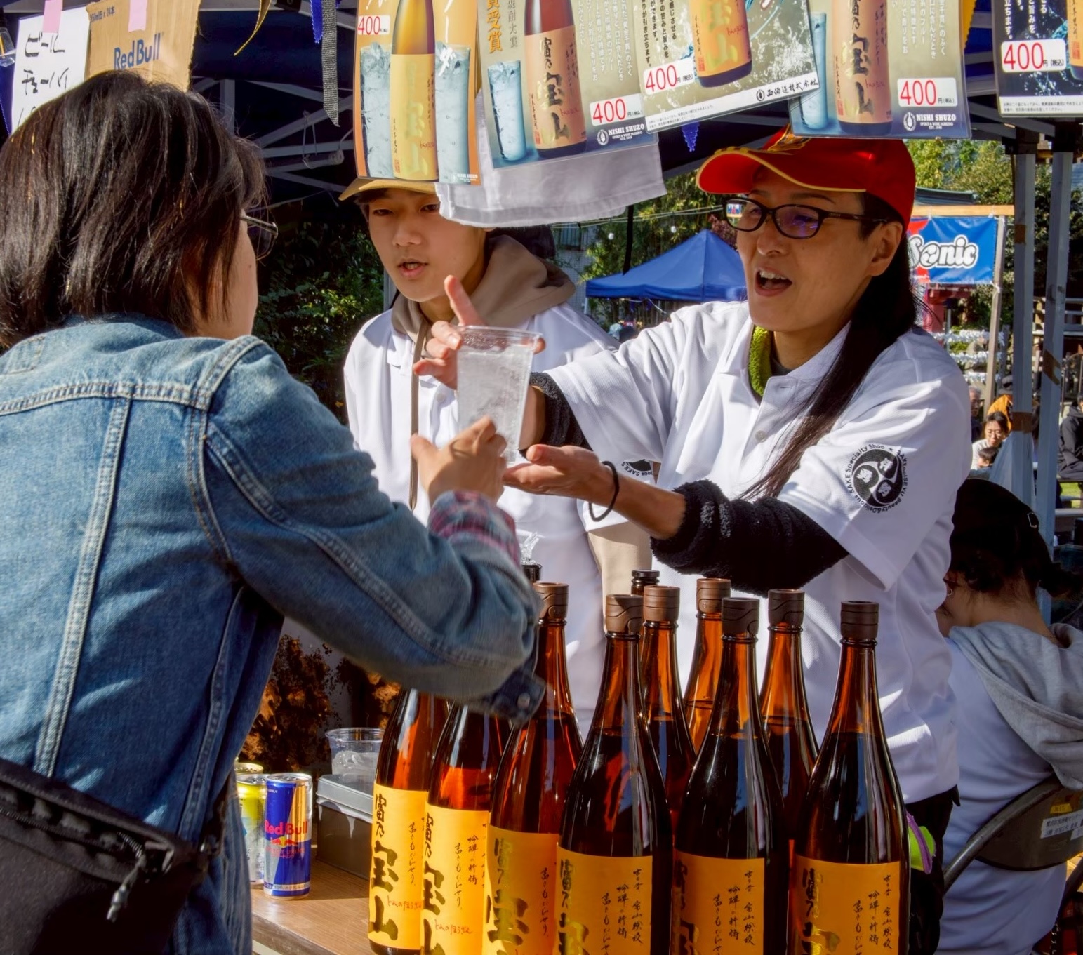 ドリンクブースで笑顔で接客するスタッフと来場者